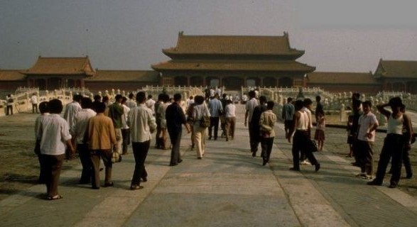 People are walking in front of the Hall of Supreme Harmony in the Forbidden City.