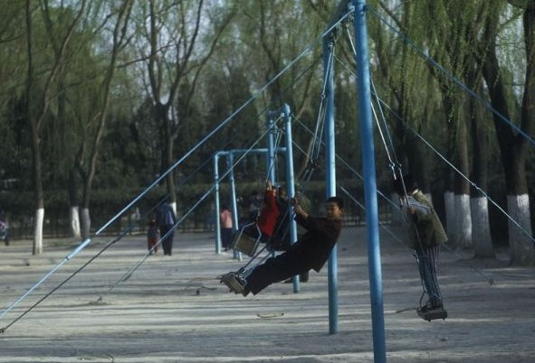 Several children are having a good time on a playground in the Ritan Park. 