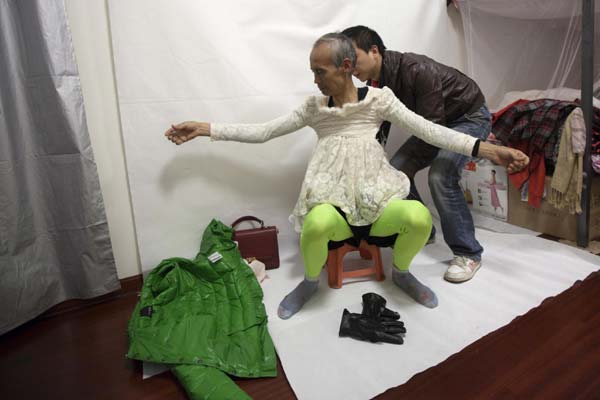72-year-old Liu Qianping, also known as 'MaDiGaGa', is helped during a modelling shoot in the southern Chinese city of Guangzhou Nov 24, 2012. [Photo/China Daily via Agencies]
