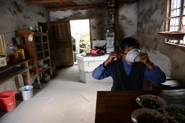 Zhong Zhaowu eats lunch at his home in Nankeng village, Anyi county in East China's Jiangxi province on Nov 6, 2012. [Photo/Xinhua] 