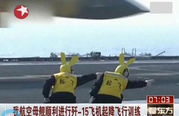 A screen capture shows commanders directing a J-15 jet taking off from and landing on China's first aircraft carrier, the Liaoning on Sunday, November 25, 2012. Their gesture has been popular on the internet with many people posting imitations of it. [Photo/sohu.com]