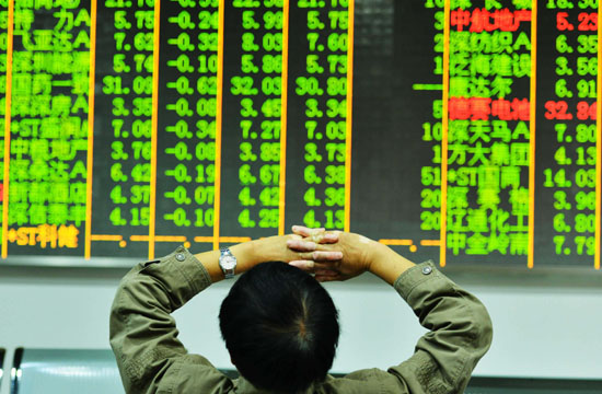 An investor monitors share prices at a brokerage in Hangzhou, Zhejiang province, on Tuesday. The benchmark Shanghai Composite Index ended trading at 1991.17 points, its lowest close in about 46 months. [Photo/China Daily]