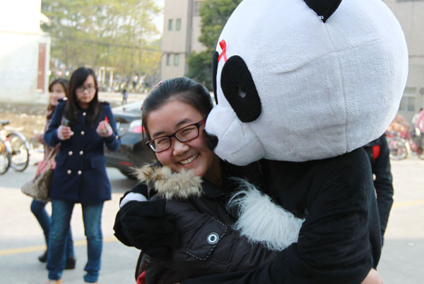 A student dressed up as a panda AIDS patient gives out hugs at Jiangsu University in East China on Nov 28, 2012. [Photo/asianewsphoto]