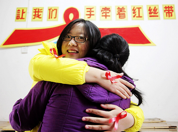Wang Ruihuan, left, a volunteer at University of South China, embraces an AIDS patient in Hengyang, Central China's Hunan province on Nov 29, 2012. To mark the World AIDS Day on Dec 1, volunteers from the university are working with the Third People’s Hospital of Hengyang to reach out to AIDS patients.[Photo/Xinhua]
