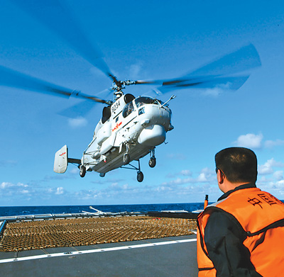 A ship-borne helicopter participates in the drills in the western Pacific Ocean Dec. 1.