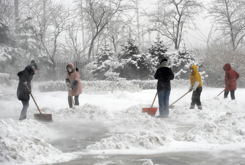 People clear off snow on the ground in Shenyang, capital of northeast China's Liaoning Province, Dec. 3, 2012. Liaoning Province issued a red alert for snowstorm on Monday morning, while closing an airport and expressways in the provincial capital of Shenyang.