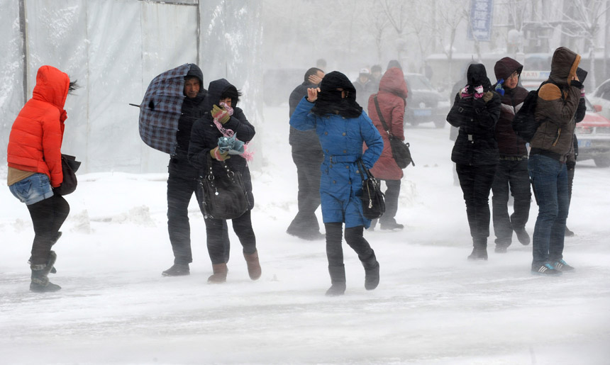 People walk hard amid snowstorm in Shenyang, capital of northeast China's Liaoning Province, Dec. 3, 2012. Liaoning Province issued a red alert for snowstorm on Monday morning, while closing an airport and expressways in the provincial capital of Shenyang.