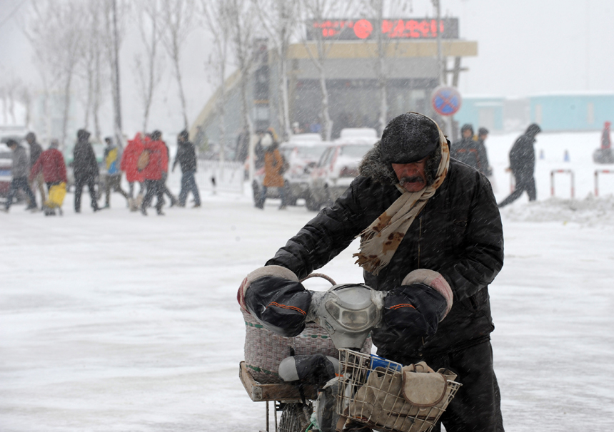 A man walks hard amid snowstorm in Shenyang, capital of northeast China's Liaoning Province, Dec. 3, 2012. Liaoning Province issued a red alert for snowstorm on Monday morning, while closing an airport and expressways in the provincial capital of Shenyang. 