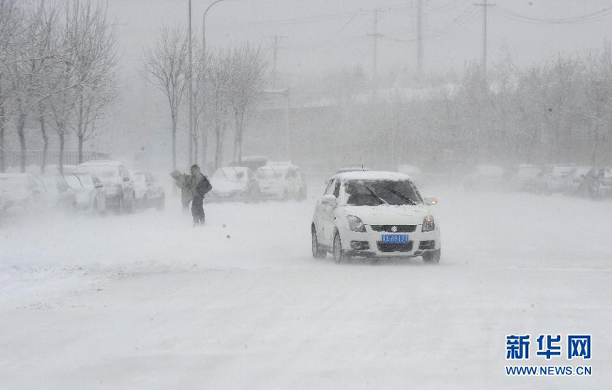 A car runs amid snowstorm in Shenyang, capital of northeast China's Liaoning Province, Dec. 3, 2012. Liaoning Province issued a red alert for snowstorm on Monday morning, while closing an airport and expressways in the provincial capital of Shenyang.