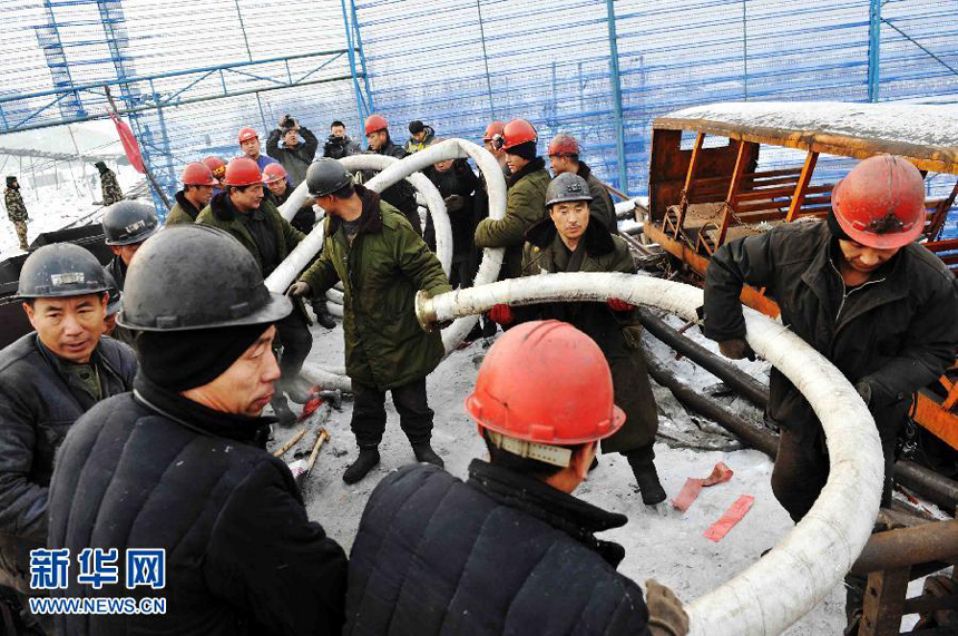 Rescuers are busy pumping water from the shaft of the coal mine in Qitaihe, northeast China&apos;s Heilongjiang Province, in an attempt to save 14 miners trapped underground by a flood on Sunday.