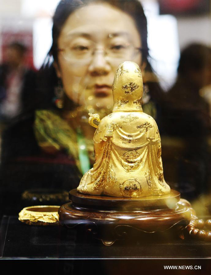 A visitor watches a work of art which is made of gold at the 8th Beijing International Finance Conference in Beijing, capital of China, Dec. 3, 2012. The four-day conference was closed on Monday.