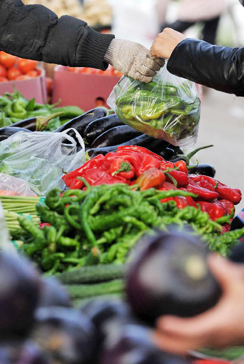 A citizen buys vegetable at a market in Yinchuan, capital of northwest China&apos;s Ningxia Hui Autonomous Region, Dec. 6, 2012. China&apos;s consumer price index (CPI), a main gauge of inflation, grew 2 percent year on year in November, the National Bureau of Statistics announced Sunday. The inflation rate increased from a 33-month low of 1.7 percent in October as food prices increased.