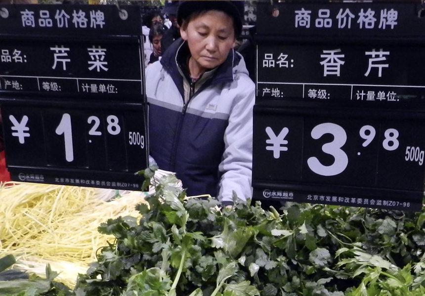 Citizens buy vegetables at a market in Beijing, Dec. 9, 2012. China&apos;s consumer price index (CPI), a main gauge of inflation, grew 2 percent year on year in November, the National Bureau of Statistics announced Sunday. The inflation rate increased from a 33-month low of 1.7 percent in October as food prices increased. 