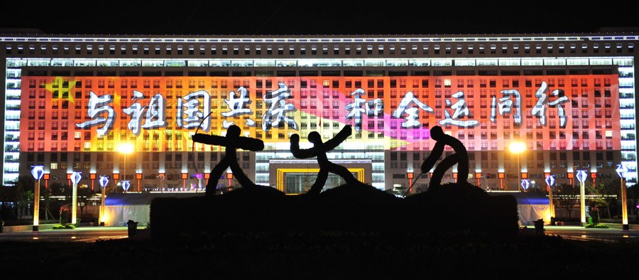 2009年10月13日，第十一届全国运动会开幕前，龙奥大厦上被打上巨幅标语。[新华社 杨光 摄]
