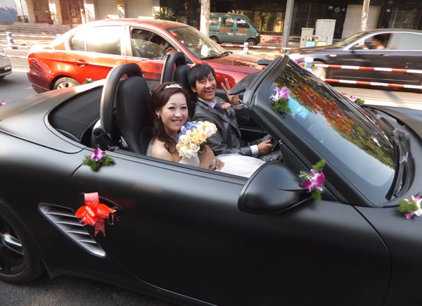A newly married couple in a luxury car. The most favorite purchases of rich Chinese tend to be leather goods and automobiles, according to the latest report by Robb and Ipsos, which said the top two products accounted for about 20 percent of Chinese millionaires' total consumption over the past year. [Wang Zhicheng / For China Daily]    