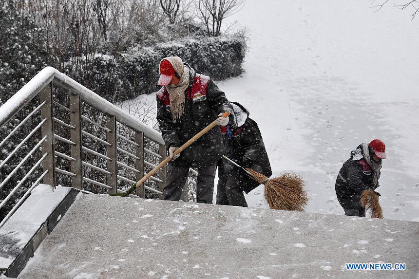 Sanitation workers sweep snow on Binhe Road in Taiyuan, capital of north China&apos;s Shanxi Province, Dec. 20, 2012. Many parts north China saw heavy snowfall on Thursday. 