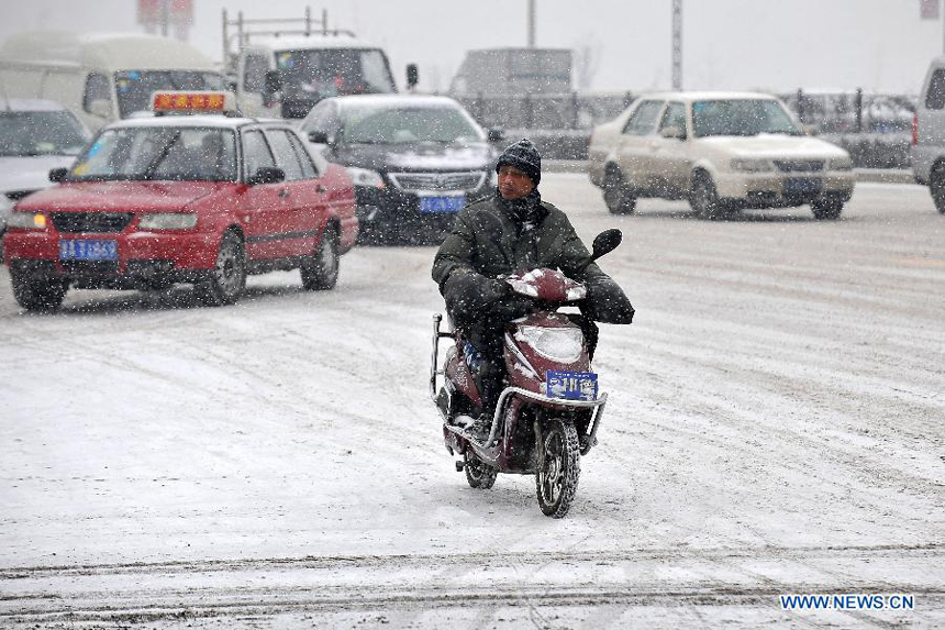  A man rides in snow on Changfeng Bridge in Taiyuan, capital of north China&apos;s Shanxi Province, Dec. 20, 2012. Many parts in Shanxi saw heavy snowfall on Thursday. 