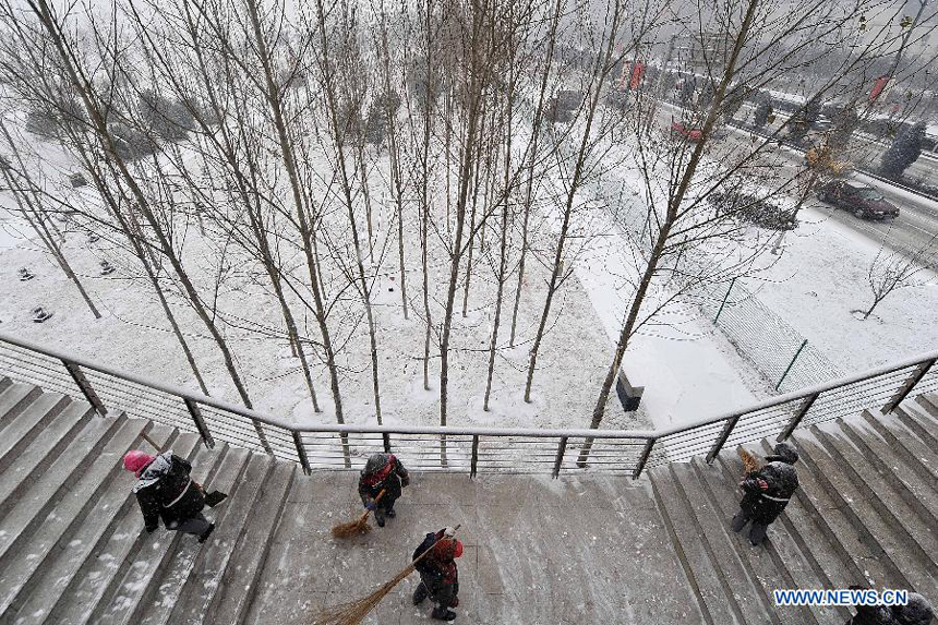 Sanitation workers sweep snow in Fenhe River scenic spot in Taiyuan, capital of north China&apos;s Shanxi Province, Dec. 20, 2012. Many parts in Shanxi saw heavy snowfall on Thursday