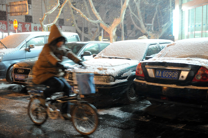 People brave the snow and cold in Zhengzhou, Henan Province, on Dec. 20, 2012. Many parts north China saw heavy snowfall on Thursday. 