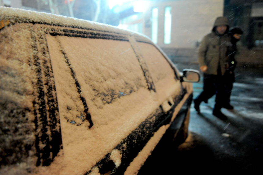 People brave the snow and cold in Zhengzhou, Henan Province, on Dec. 20, 2012. Many parts north China saw heavy snowfall on Thursday. 