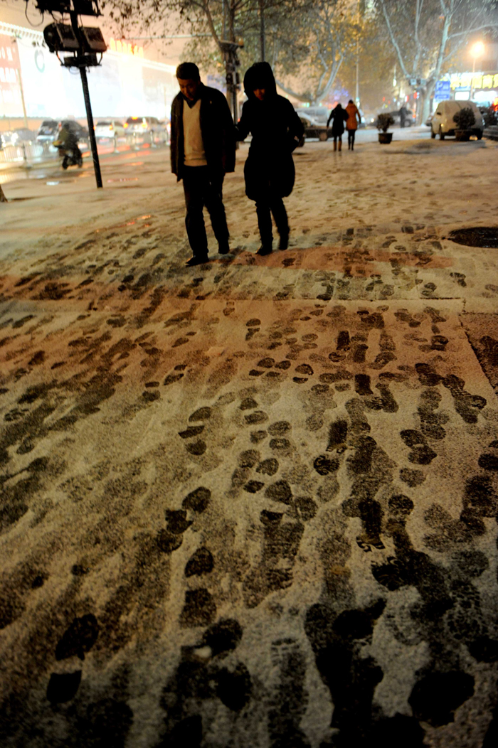 People brave the snow and cold in Zhengzhou, Henan Province, on Dec. 20, 2012. Many parts north China saw heavy snowfall on Thursday.