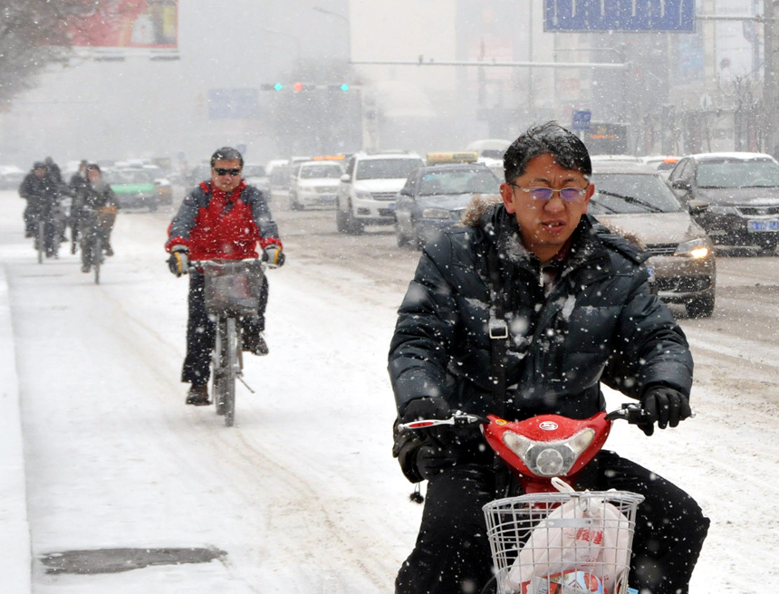 People brave the snow and cold in Hohhot, Inner Mongolia Autonomous, on Dec. 20, 2012. Many parts north China saw heavy snowfall on Thursday. [Xinhua photo]