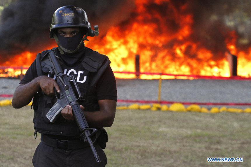 An element of the National Drug Control (DNCD, for it&apos;s acronym in Spanish) of the Dominican Republic stands guard during a drug burning at the Pedro Brand municipality, in Santo Domingo, Dominican Republic, on Dec. 20, 2012. According to the DNCD, 3,240 kg of pure cocaine, 325 kg and 766 marijuana plants, 15 kg of heroin and 4 kg of crack were burned on Thursday. The drugs were seized in the past five months in Santo Domingo. 