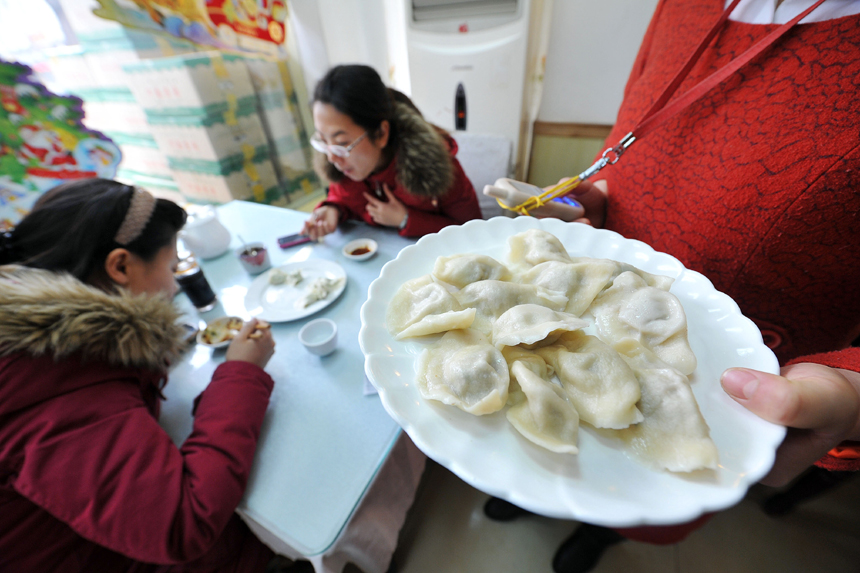 People enjoy dumplings in a restaurant in Dalian, Liaoning Province, on Dec. 21. 