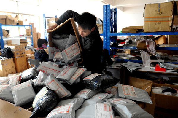  A worker at an online shop in Yiwu, Zhejiang province, sorts out parcels to be delivered this month.[Photo/China Daily]