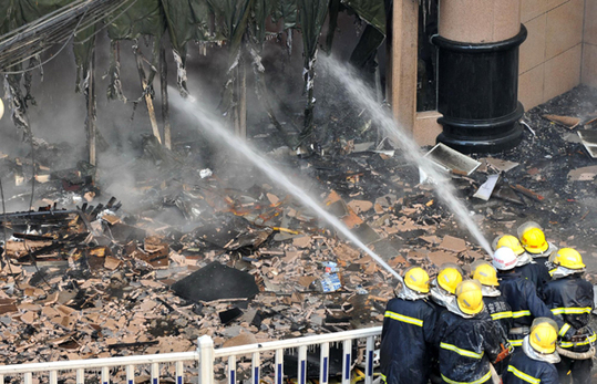 Firefighters try to extinguish a fire that broke out in a commercial building in Yan'an, Northwest China's Shaanxi province, Dec 22, 2012. [Xinhua] 