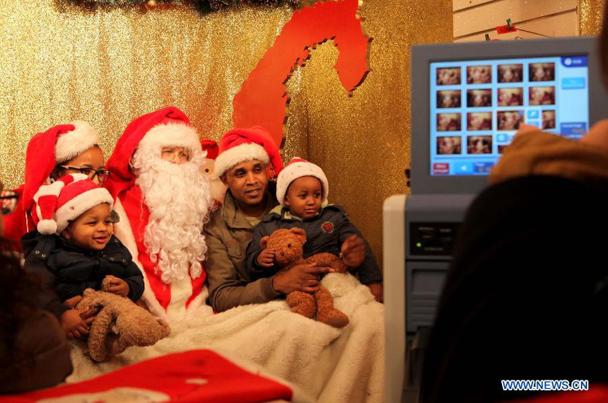 A family poses with Santa at the Christmas market on the Champs-Elysees avenue in Paris, France, Dec. 23, 2012.