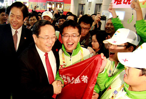 File photo taken on Oct. 31, 2010 shows Yu Zhengsheng (2nd L,front) visits volunteers working at the Shanghai World Expo in east China's Shanghai Municipality. [Photo/Xinhua]