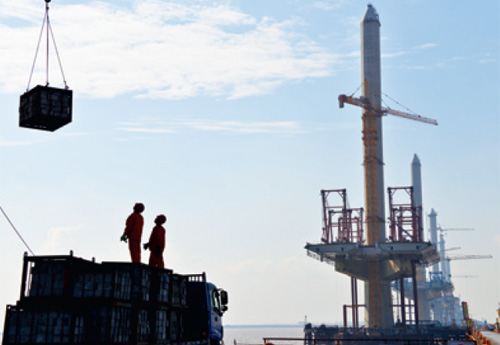 Workers appear close by the main tower of the Jiaxing-Shaoxing (Jiashao) Bridge on the Hangzhou Bay, east China's Zhejiang Province, on February 22. As the second cross-sea bridge spanning the Hangzhou Bay, the Jiashao Bridge will halve the travel time between Shaoxing in Zhejiang and Shanghai to 1.5 hours [Photo by Xu Yu]