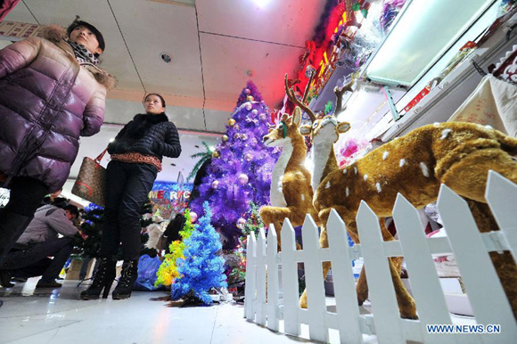 People select Christmas ornaments at a holiday decoration store in Yinchuan, capital of northwest China's Ningxia Hui Autonomous Region, Dec. 19, 2012. As Christmas is drawing near, shopping malls and decoration stores in Yinchuan start to sell related decoration articles.