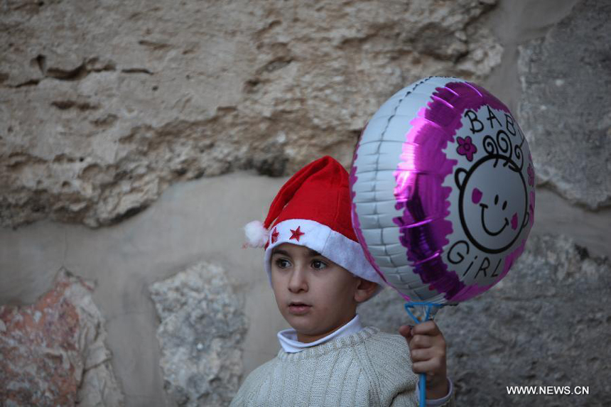 A Palestinian boy stands outside the Church of the Nativity as he attends the Christmas celebrations in the West Bank town of Bethlehem on Dec. 24, 2012.
