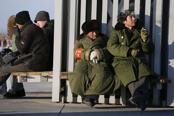 Smokers take a break at the Olympic Green in Beijing on Sunday. [Photo/China Daily]