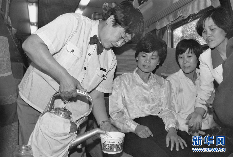 这是1993年拍摄的京广铁路线上的列车员王艳华在为旅客服务。[新华社]