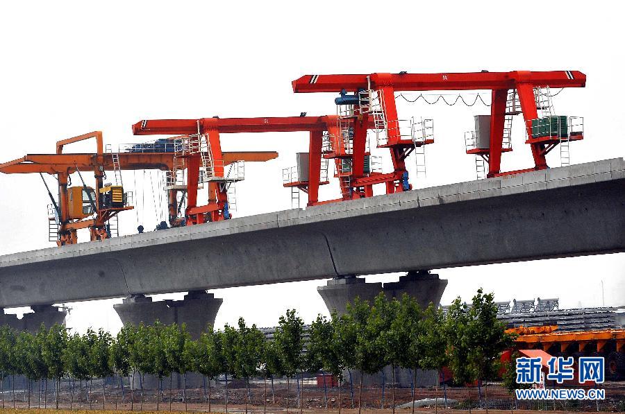 这是2010年6月3日，京广铁路客运专线石武高铁（河南段）新乡市境内的一处工地上在铺设铁轨。[新华社]