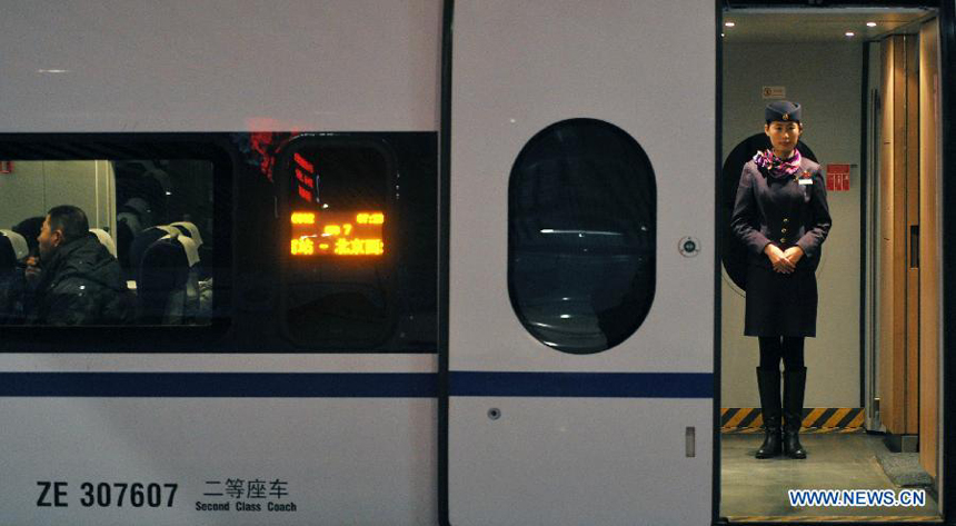 A stewardess wait to serve passengers in high-speed train G502 at the Changsha South Railway Station in Changsha, capital of central China's Hunan Province, Dec. 26, 2012.