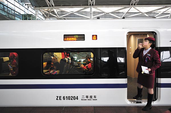 In a throwback to another era, an attendant whistles for passengers to board the high-speed train for Beijing at Guangzhou South Railway Station on Wednesday. The train was set for its maiden journey on the world’s longest high-speed track. [Photo/ China News Service]