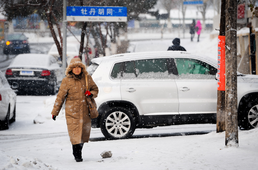 People walk in snow on a street in Changchun, capital of northeast China&apos;s Jilin Province, Dec. 28, 2012. Most parts of Jilin on Friday saw a snowfall, which would be followed by a significant temperature drop on Saturday. 