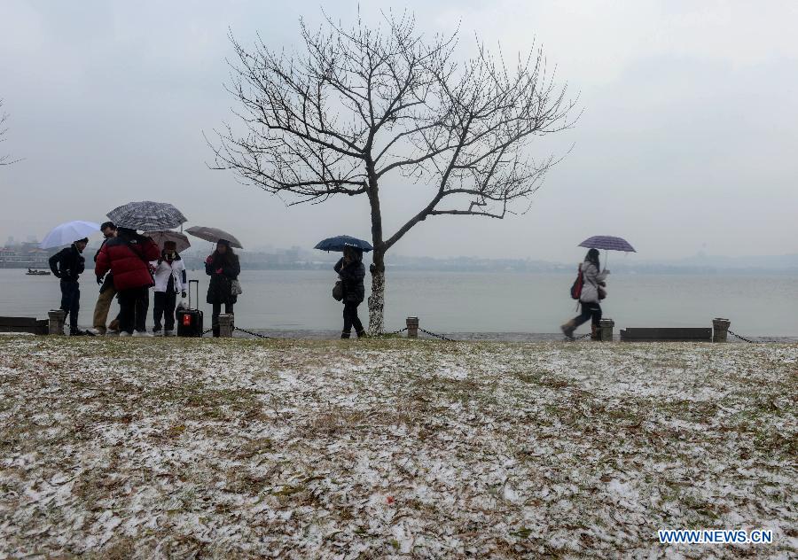 Tourists visit the West Lake scenic spot in snow in Hangzhou, capital of east China's Zhejiang Province, Jan. 3, 2013. The central and northern parts of Zhejiang witnessed on Thursday the first snow in 2013. 