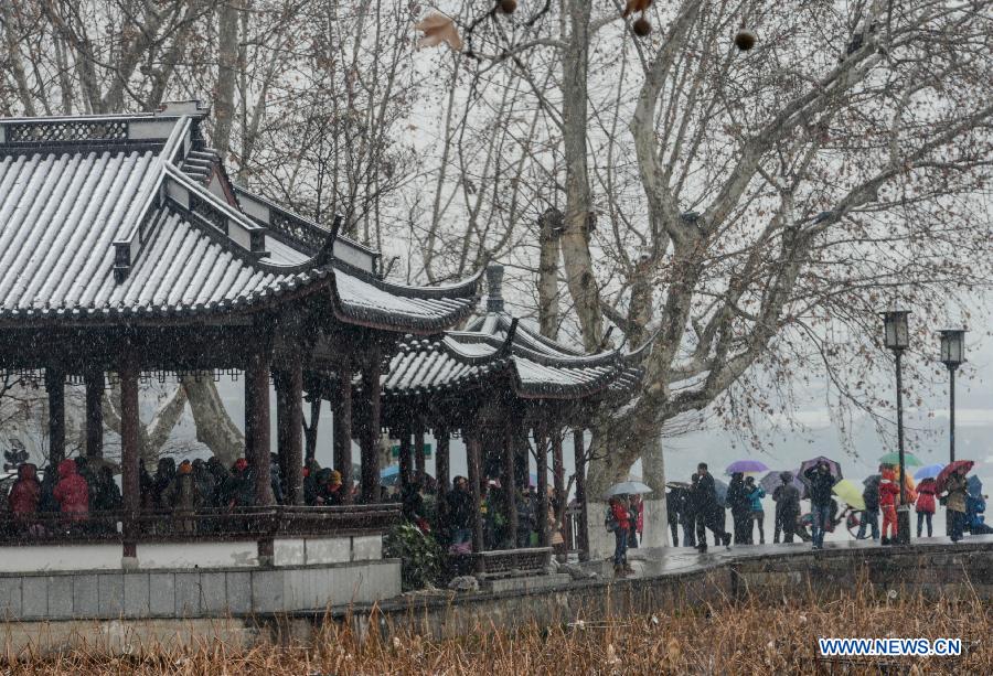 Tourists visit the West Lake scenic spot in snow in Hangzhou, capital of east China's Zhejiang Province, Jan. 3, 2013. The central and northern parts of Zhejiang witnessed on Thursday the first snow in 2013.