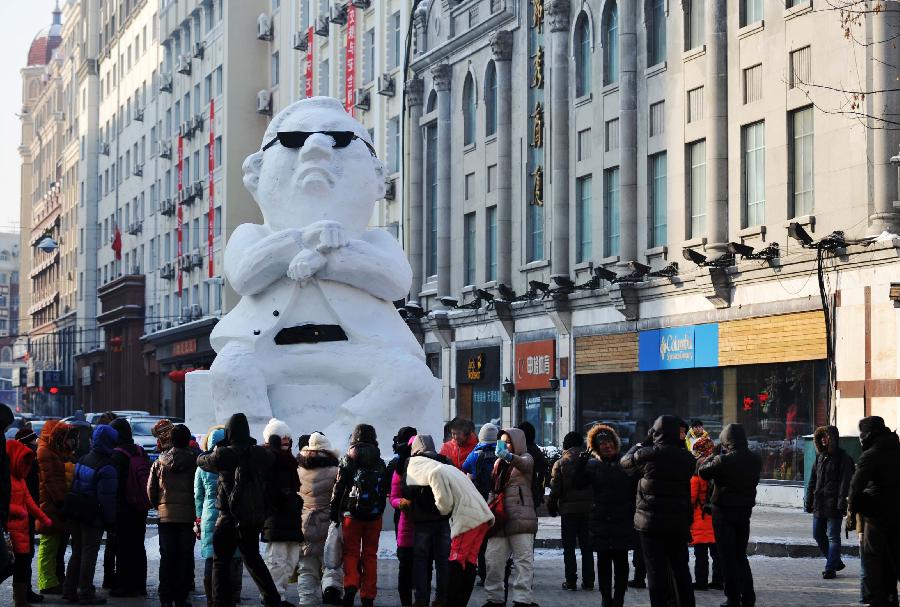 Tourists gather in front of a snow sculpture of South Korean rapper Psy in Harbin, capital of northeast China's Heilongjiang Province, Jan. 2, 2013. Psy's music video of 'Gangnam Style,' featuring the horse-riding dance, became a global sensation this year. (Xinhua/Wang Jianwei) 