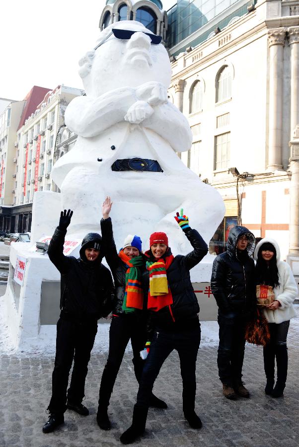 Tourists pose for photo in front of a snow sculpture of South Korean rapper Psy in Harbin, capital of northeast China's Heilongjiang Province, Jan. 2, 2013. Psy's music video of 'Gangnam Style,' featuring the horse-riding dance, became a global sensation this year. (Xinhua/Wang Jianwei) 