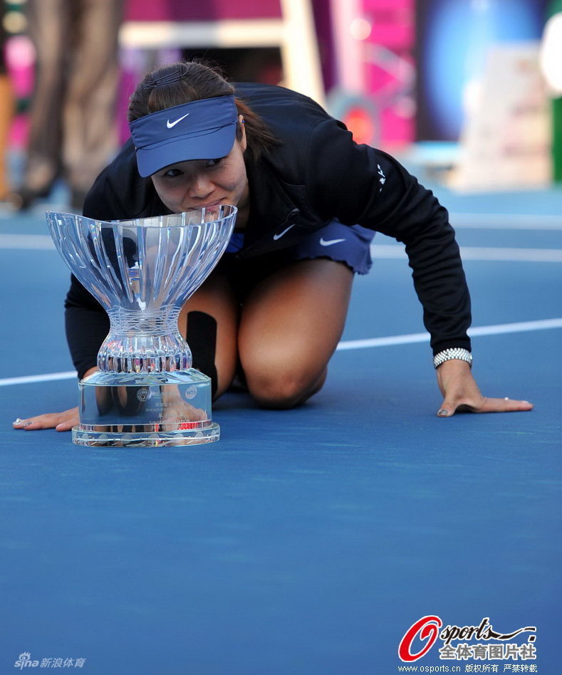  Li Na poses with the trophy after winning the Shenzhen Open final.