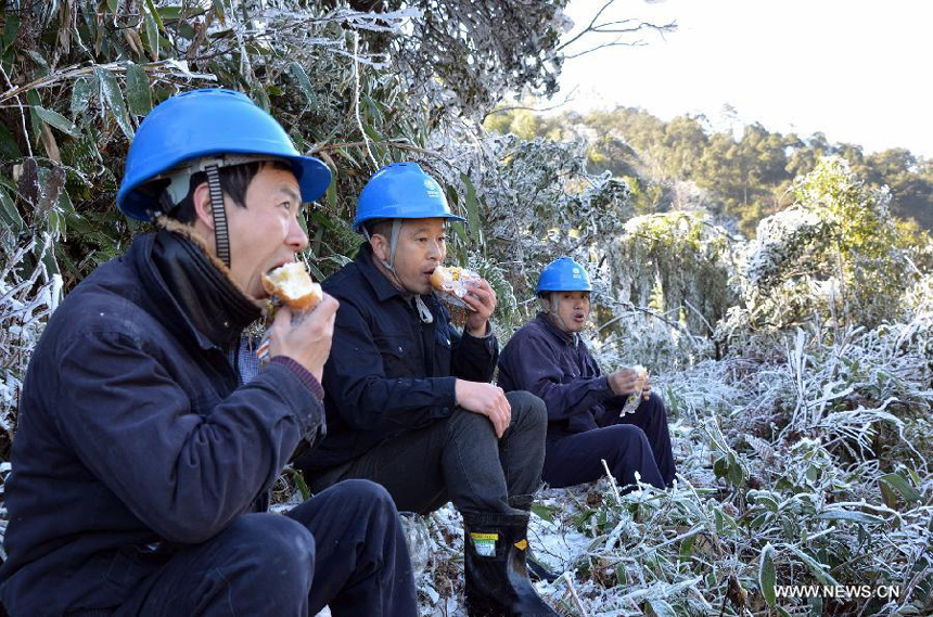 Staff members of local power supply bureau have a meal while checking power transmission lines in Nanping City, southeast China&apos;s Fujian Province, Jan. 5, 2013. Nanping Power Supply Bureau took measures to repair the mal-functioned power transmission lines affected by the freezing rain and snow weather here in recent days. 