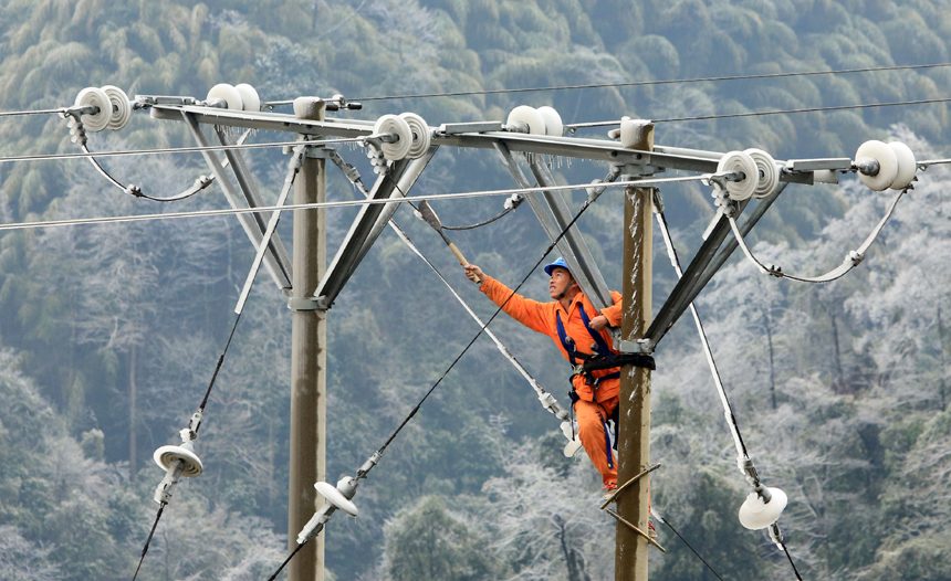 A staff member of local power supply bureau repairs the damaged power transmission lines in Rong'an County, Liuzhou City, Guangxi Zhuang Autonomous Region, Jan. 6, 2013. Power transmission lines have been affected by the freezing rain and snow weather here in recent days.