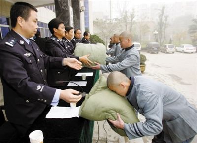 2006年11月22日，西安，20名劳教人员从劳教所民警手中接过赠送的过冬棉被棉衣。[资料图]