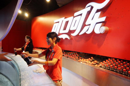 Workers promoting Coca-Cola soft drink at a supermarket in Beijing. A senior Coca-Cola China executive said on Tuesday that the company has filed a police report about recent rumors that its orange juice contains illegal fungicide. [File Photo]